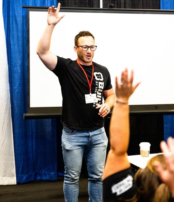 Hudson Wikoff on stage with the room's hands raised